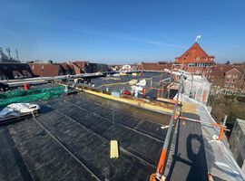 Bautenstand vom 18.03.2026: Die Arbeiten auf der Baustelle entwickeln sich weiterhin sehr positiv. Der Rohbau ist vollständig abgeschlossen, sodass das Gebäude mit eingebauten Fenstern und Haustüren bereits seine endgültige Form erkennen lässt. Damit ist ein wesentlicher Meilenstein in der Projektentwicklung erreicht.  Auch im Bereich der Dacharbeiten wurden entscheidende Fortschritte erzielt: Sämtliche vorbereitenden Maßnahmen sind abgeschlossen, aktuell erfolgt die Abdichtung des Hauptdachs. Parallel dazu schreiten die technischen Ausbaugewerke zügig voran. Die Elektroinstallation sowie die Arbeiten in den Bereichen Heizung, Sanitär und Lüftung sind bereits weit fortgeschritten und werden planmäßig in den oberen Geschossen fortgeführt.  Im Innenausbau zeigt sich ebenfalls ein hoher Fertigstellungsgrad. Die Trockenbauarbeiten sind größtenteils umgesetzt, erste Bereiche bereits geschlossen. Die Dämmarbeiten im Keller stehen kurz vor dem Abschluss, und die Stahlzargen für die Innentüren wurden erfolgreich eingebaut.  Darüber hinaus sind die Estricharbeiten im Kellergeschoss abgeschlossen und werden derzeit im Erdgeschoss fortgeführt. Zeitgleich haben die Fassadenarbeiten begonnen, wodurch das Gebäude auch äußerlich zunehmend Gestalt annimmt.  Insgesamt verläuft die Umsetzung des Projekts planmäßig und entspricht unseren hohen Qualitätsansprüchen.