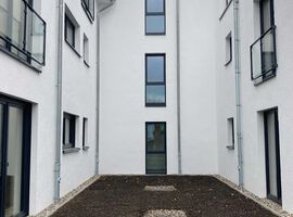 28.04.2023: Das Gelände wurde modelliert. Der Mutterboden wurde aufgebracht und der Rasen darauf gesät. Die Zuwegungen und auch der Müllplatz sind gepflastert und auch die Dachbegrünung im Hinterhof wurde bereits angelegt.