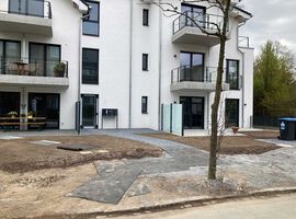 28.04.2023: Das Gelände wurde modelliert. Der Mutterboden wurde aufgebracht und der Rasen darauf gesät. Die Zuwegungen und auch der Müllplatz sind gepflastert und auch die Dachbegrünung im Hinterhof wurde bereits angelegt.